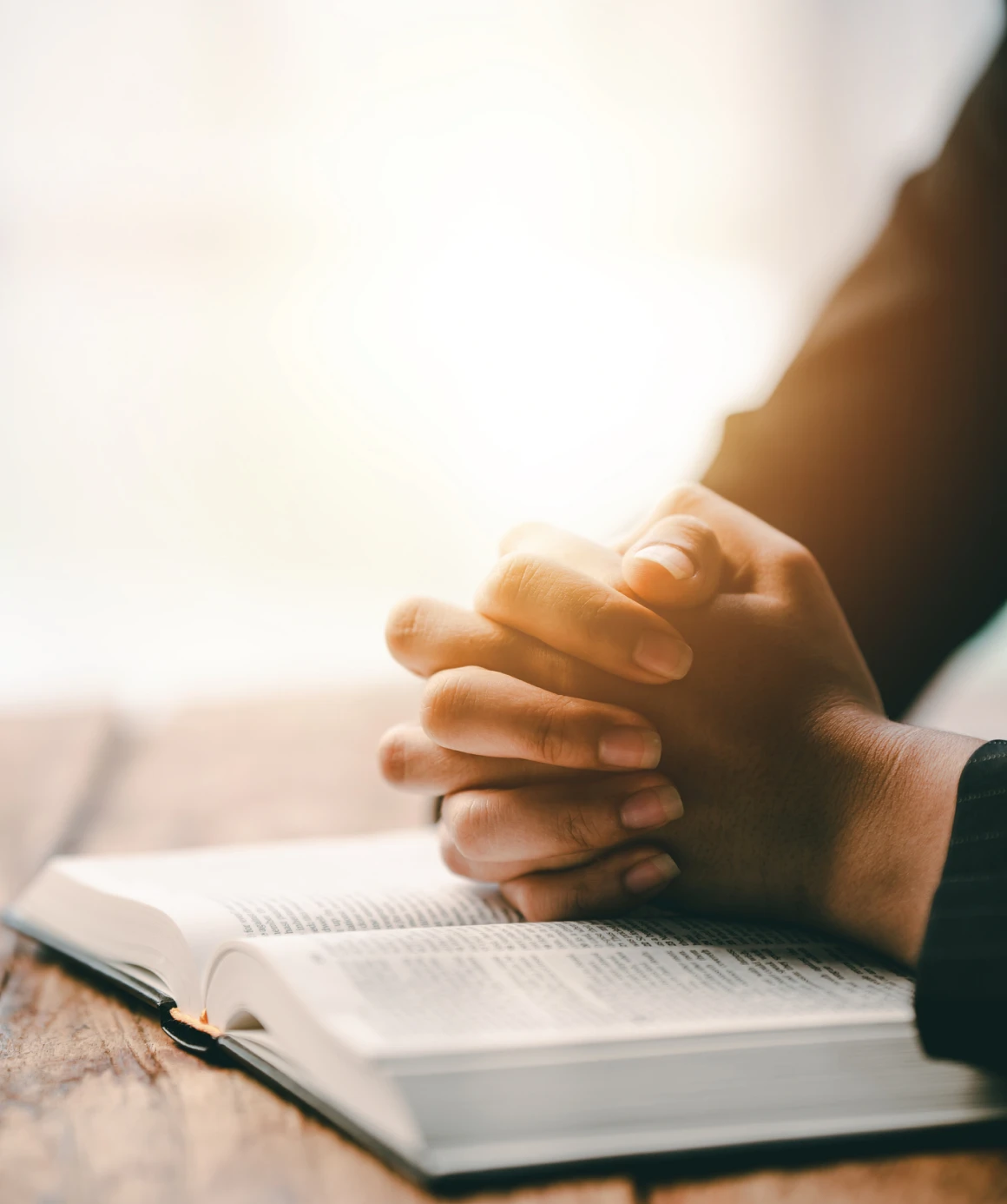 Praying hands on a Bible