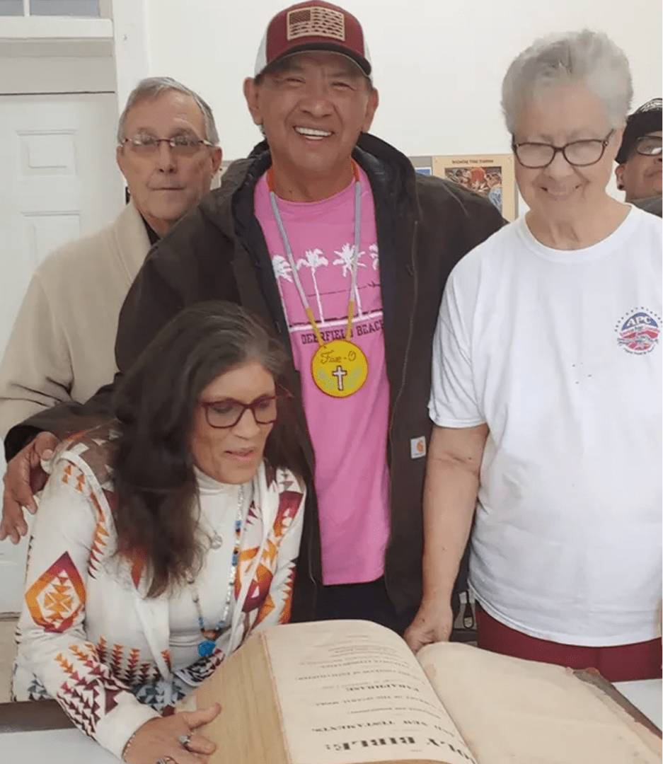 Smiling group examining a large book