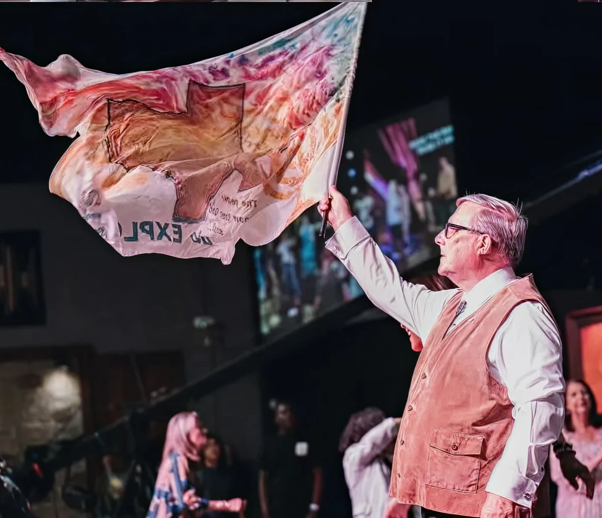 Individual holding artistic flag in crowd
