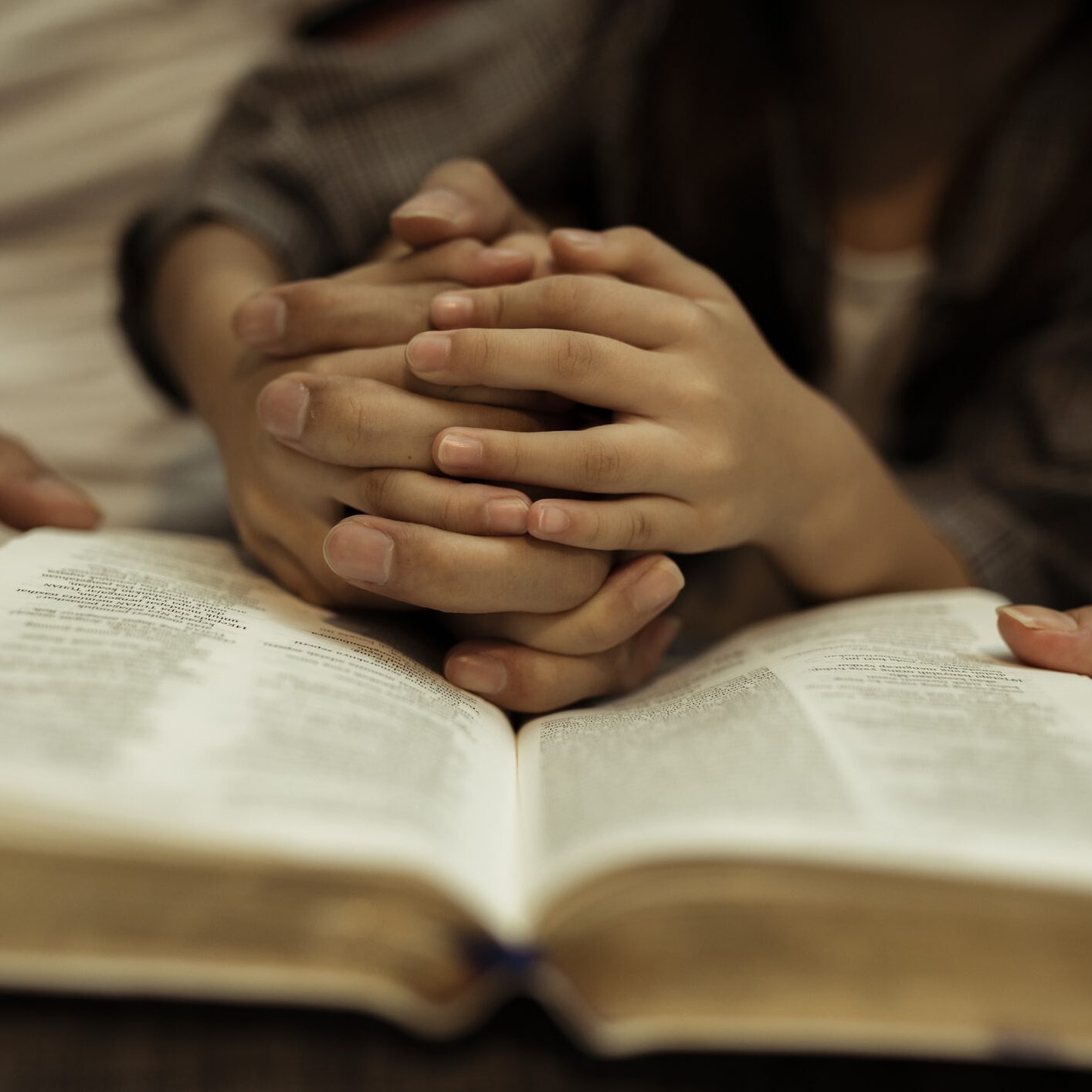 a kid reading the holy bible with guide by parents